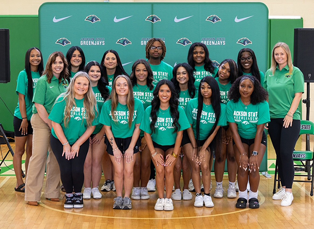 JSCC Cheer Club posing for a group photo in front of a green JSCC Athletics backdrop