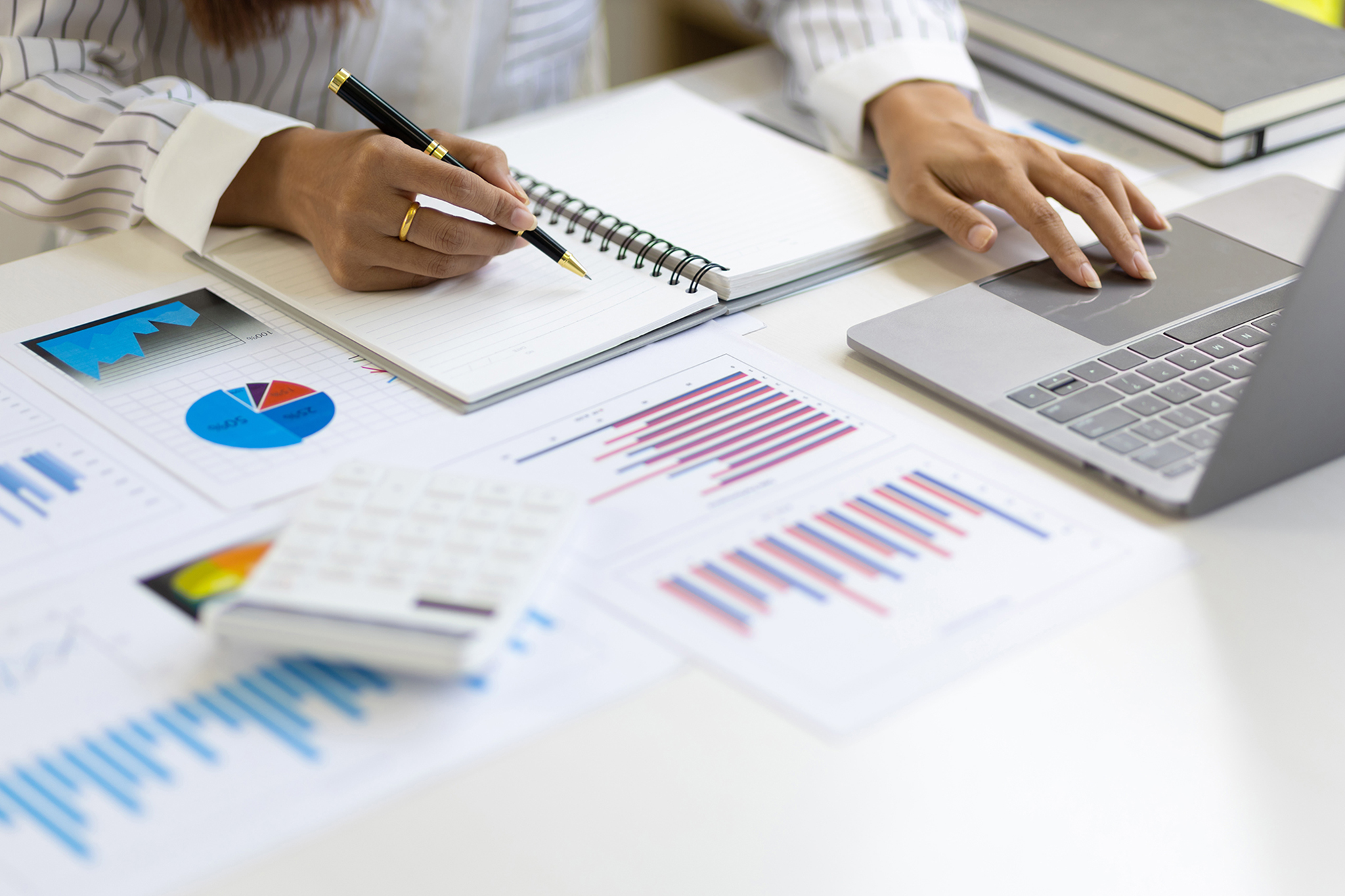 Stock photo of someone working at a desk with documents and charts