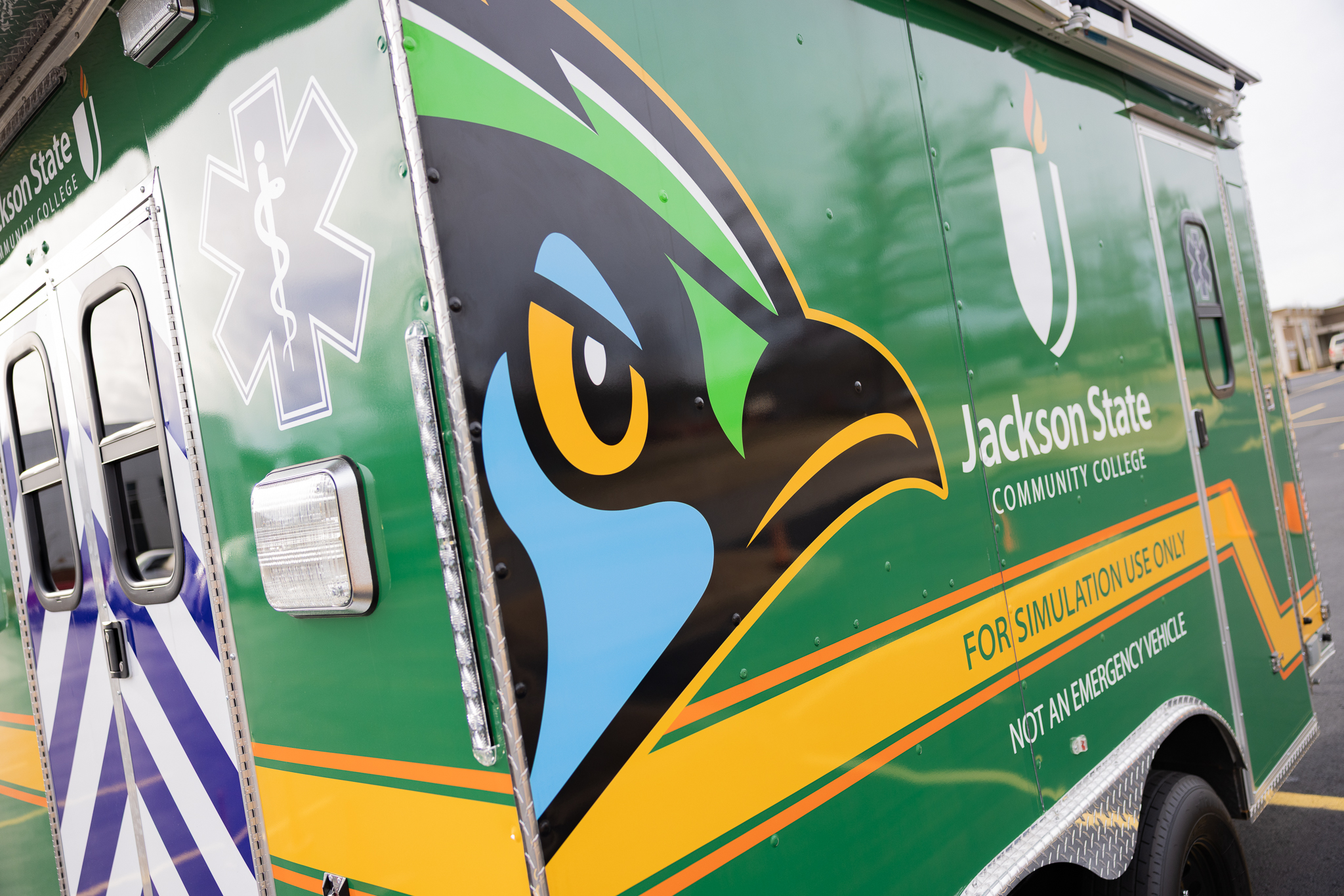 Image of the side of the JSCC EMT/Paramedic Simulator showing the JSCC Green Jay Graphic on the side of the simulator.