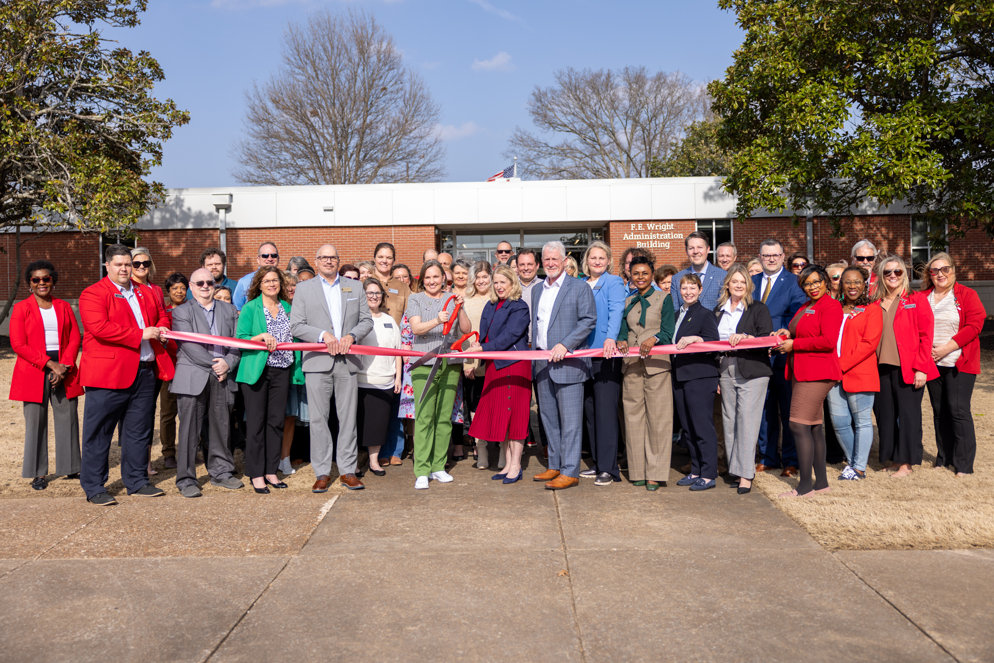 Ribbon-Cutting photo in front of the F.E. Wright Administration Building featuring JSCC President Dr. Carol Rothstein (center) beside TBR Chancellor Flora Tydings (center). TBR Regent Kyle Spurgeon is also featuring on in the middle of the photo, holding the ribbon during the ceremony.